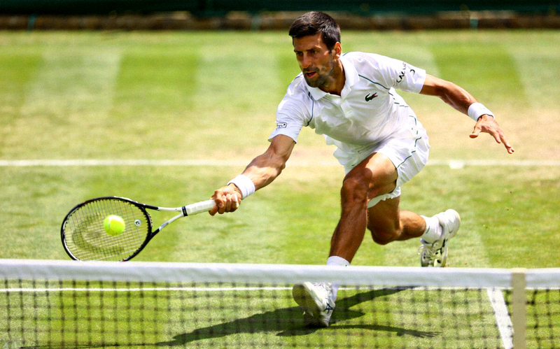 温布尔登网球锦标赛草地上球员奋力挥拍击球瞬间